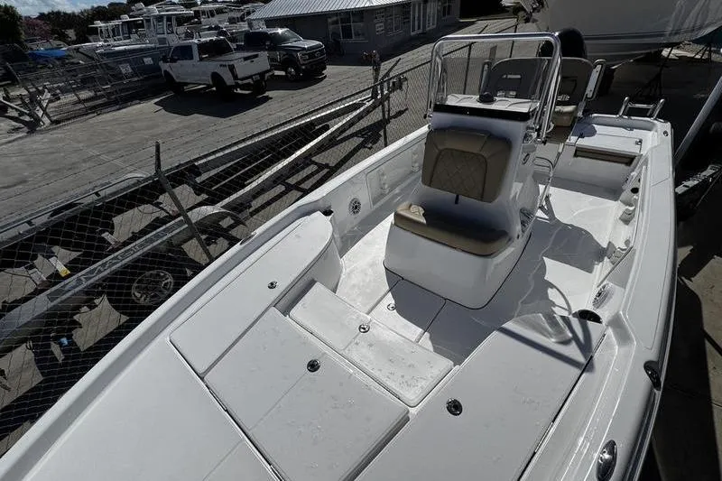 Slide: The Image of 2026 Blazer PureBay 2200 boat, white interior, docked at marina with vehicles in background. - 11