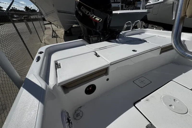 Slide: The Image of 2026 Blazer PureBay 2200 boat deck with Yamaha engine, docked near a fence. - 25