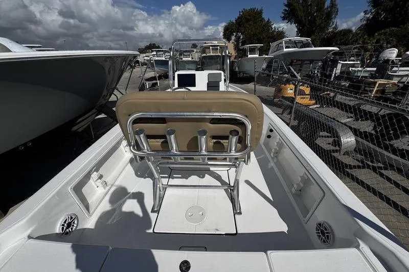 Slide: The Image of 2026 Blazer PureBay 2200 boat interior with seating and console, docked under cloudy sky. - 27
