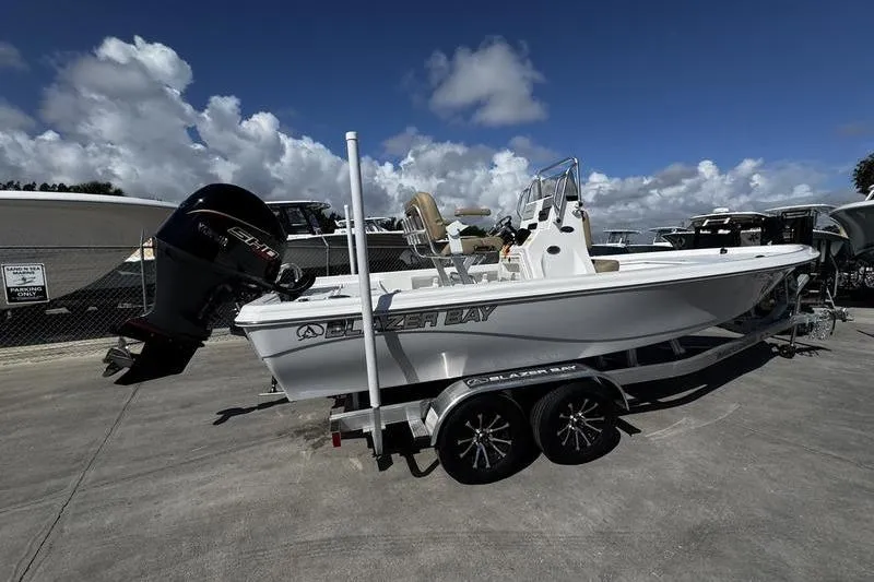 Slide: The Image of 2026 Blazer PureBay 2200 boat on trailer under a clear blue sky. - 3