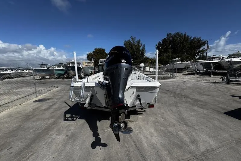 Slide: The Image of 2026 Blazer PureBay 2200 boat with outboard motor in a marina setting. - 6