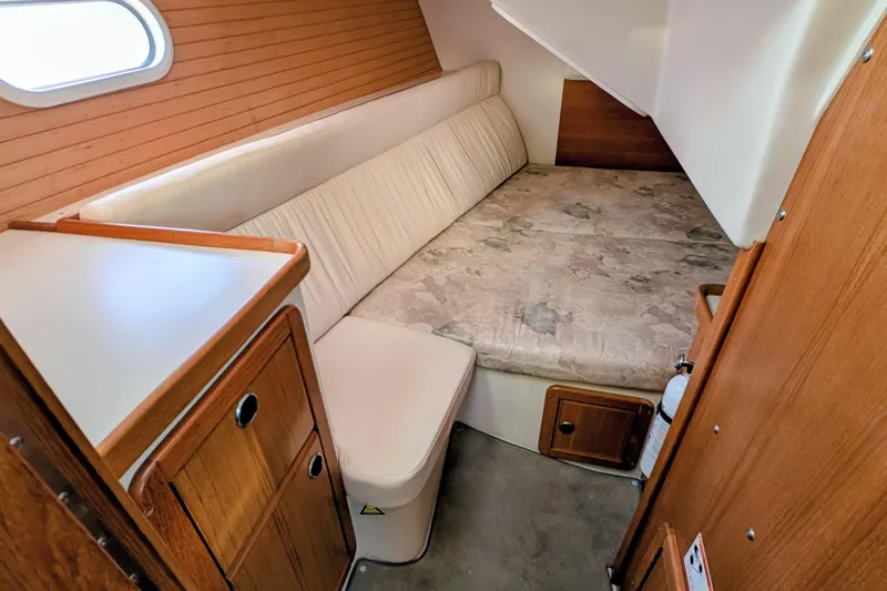 Slide: The Image of 2003 Catalina 34 MkII cabin interior with cozy bed and wooden cabinetry. - 12