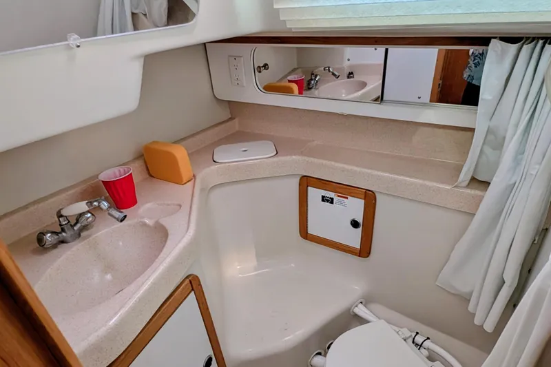 Slide: The Image of 2003 Catalina 34 MkII sailboat bathroom with sink, mirror, and storage. - 14