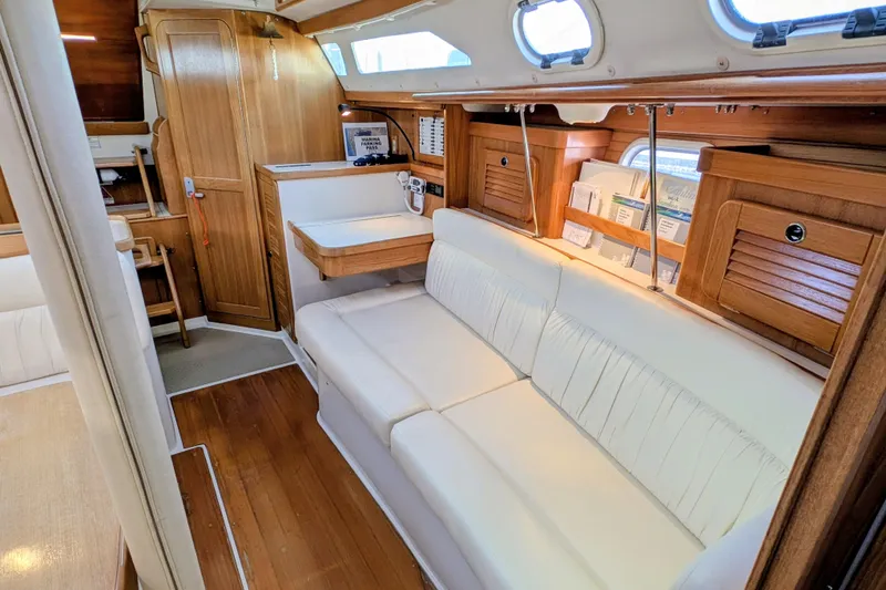Slide: The Image of Interior of 2003 Catalina 34 MkII sailboat with white seating and wooden cabinetry. - 6