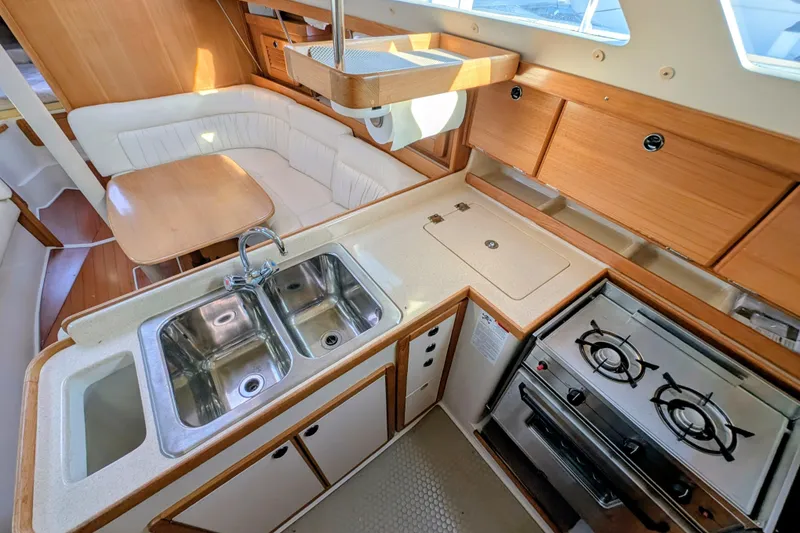 Slide: The Image of 2003 Catalina 34 MkII yacht interior with kitchen, stove, sink, and dining area. - 8