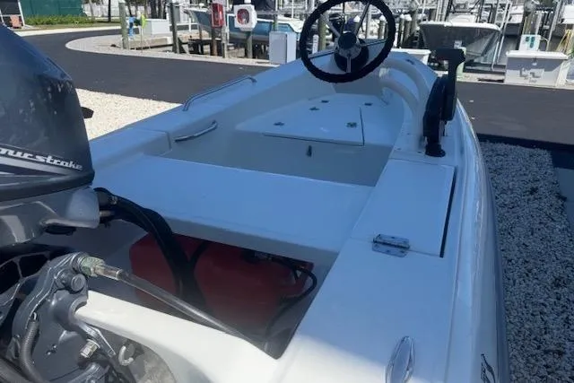 Slide: The Image of 2024 Rigid Boats 10 Sport, white motorboat with steering wheel, docked at marina. - 15
