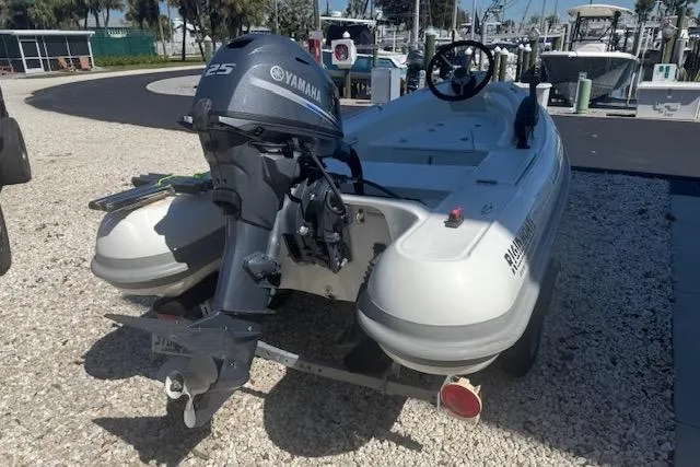 Slide: The Image of 2024 Rigid Boats 10 Sport with Yamaha 25 engine, parked on gravel. - 3