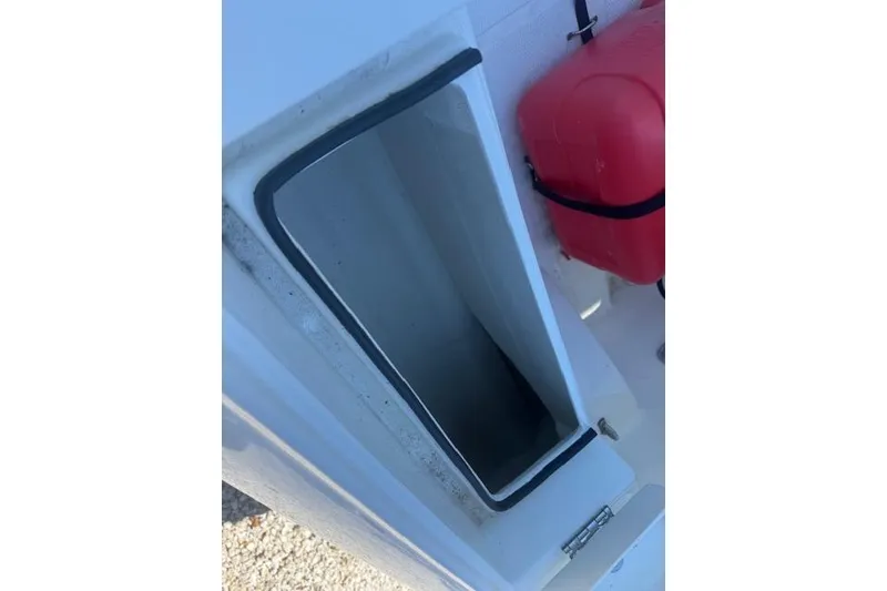 Slide: The Image of 2024 Rigid Boats 10 Sport interior compartment with red storage container. - 8