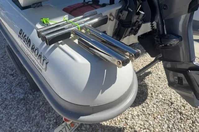 Slide: The Image of 2024 Rigid Boats 10 Sport with stainless steel fittings and outboard motor, on gravel surface. - 9