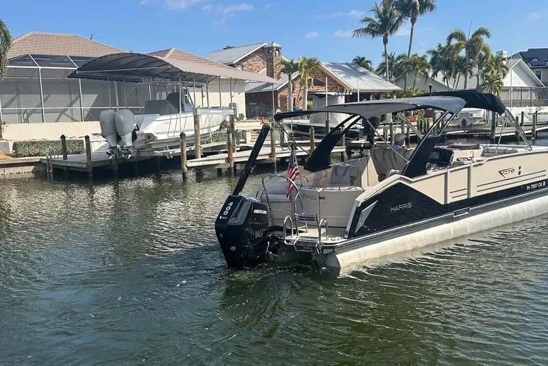 Slide: The Image of 2017 Harris V270 pontoon boat docked in a sunny marina with palm trees. - 5