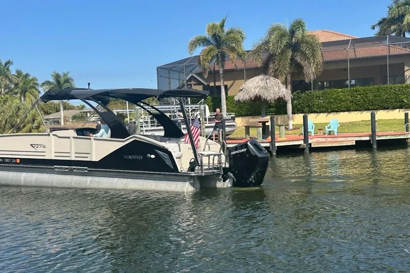 Slide: The Image of 2017 Harris V270 boat docked near a waterfront home with palm trees. - 6