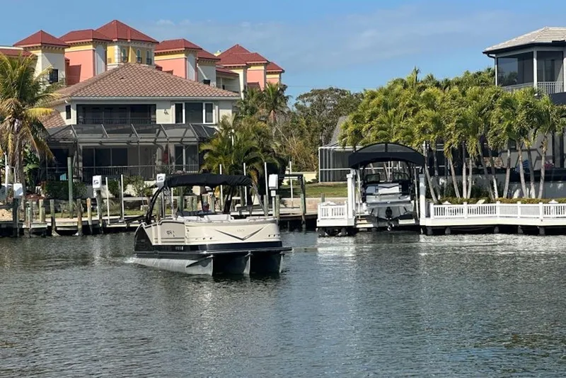 Slide: The Image of 2017 Harris V270 boat cruising near waterfront homes with palm trees. - 7