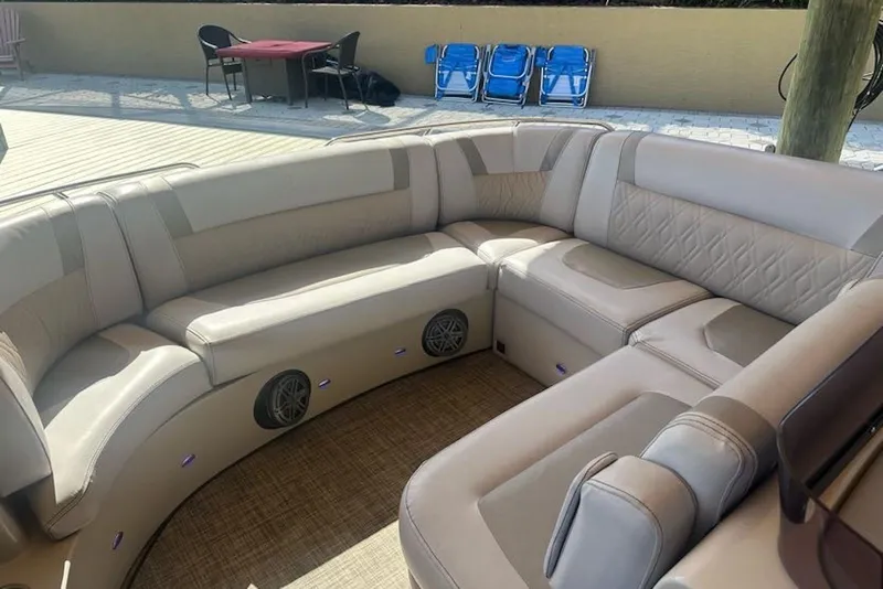 Slide: The Image of Luxurious seating on a 2017 Harris V270 boat, featuring beige upholstery and integrated speakers. - 9