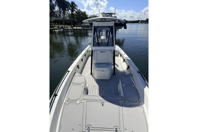 Slide: The Image of 2023 Pathfinder 2600 TRS boat on calm water, showcasing spacious deck and sleek design. - 6