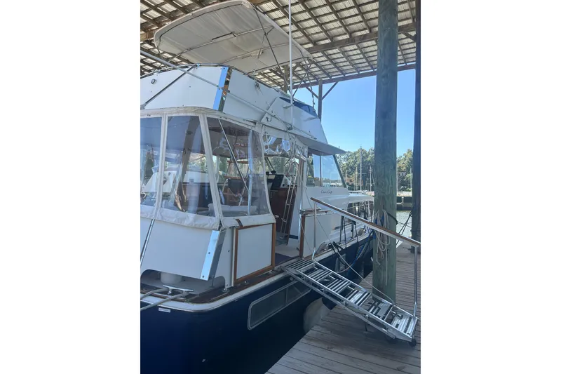 Slide: The Image of 1978 Chris-Craft 45 Commander yacht docked under a covered marina. - 15