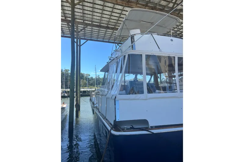 Slide: The Image of 1978 Chris-Craft 45 Commander yacht docked under a covered marina. - 17