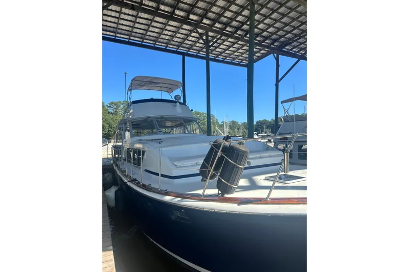 Slide: The Image of 1978 Chris-Craft 45 Commander yacht docked under a covered marina. - 2