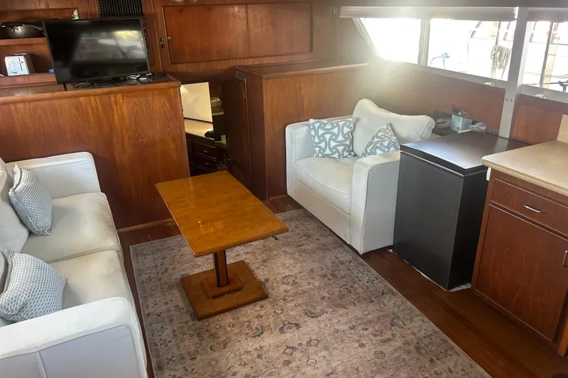 Slide: The Image of 1978 Chris-Craft 45 Commander interior with cozy seating, wooden table, and natural light. - 23