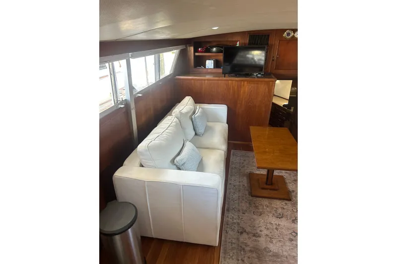 Slide: The Image of Interior of 1978 Chris-Craft 45 Commander with white sofa, wooden table, and TV. - 24