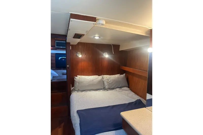Slide: The Image of Cozy cabin interior of 1978 Chris-Craft 45 Commander yacht with wood paneling and bed. - 27