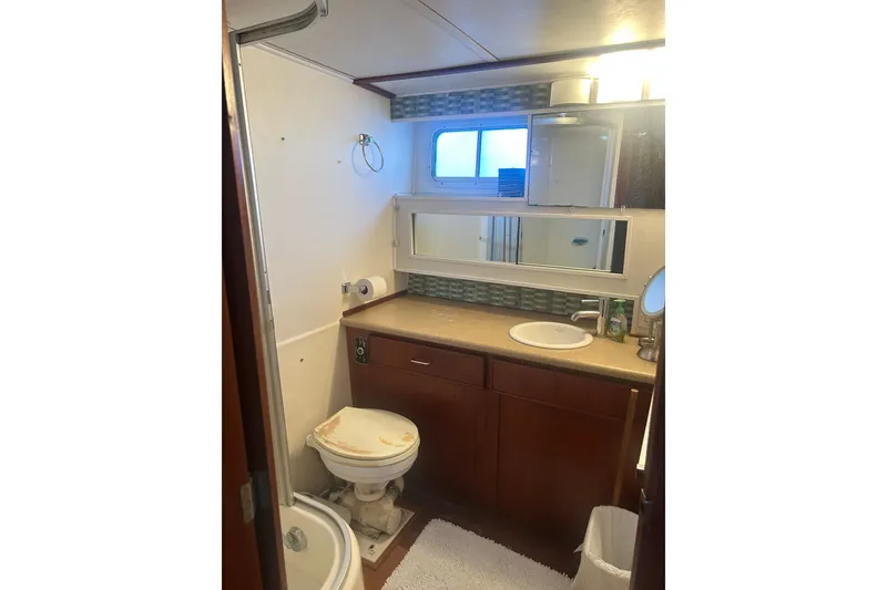 Slide: The Image of 1978 Chris-Craft 45 Commander yacht bathroom with sink, toilet, and mirror. - 32