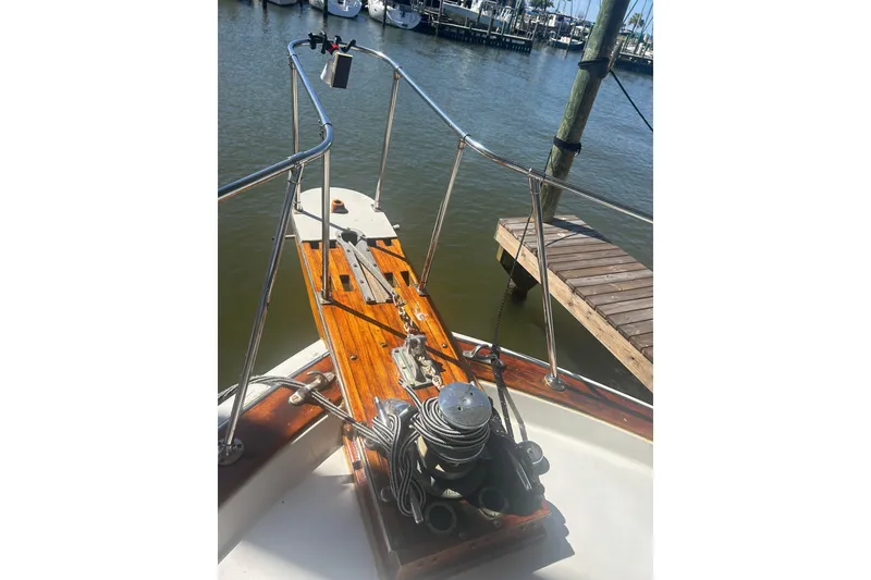 Slide: The Image of 1978 Chris-Craft 45 Commander boat deck with polished wood and metal railings at a marina. - 4