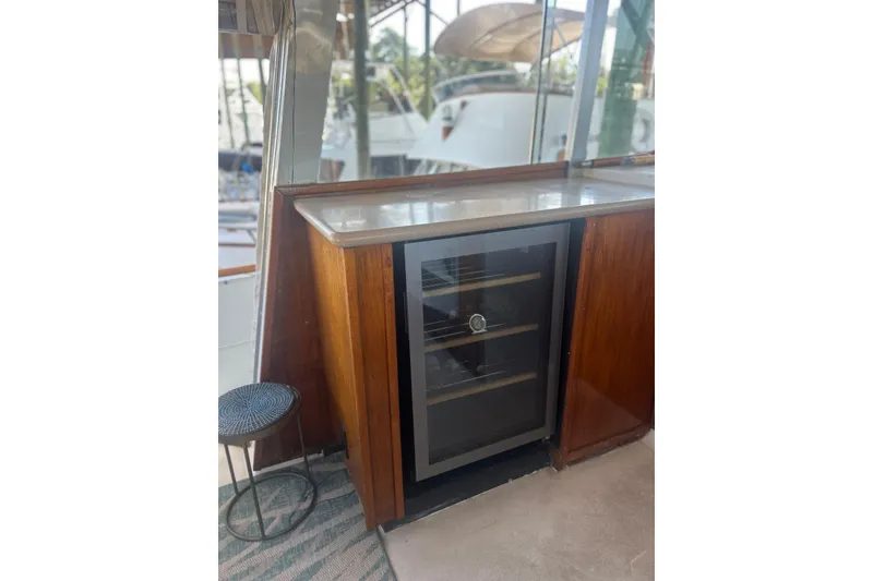 Slide: The Image of 1978 Chris-Craft 45 Commander interior with wooden cabinetry and a glass-fronted wine cooler. - 44