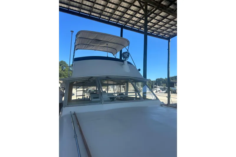 Slide: The Image of 1978 Chris-Craft 45 Commander yacht under a covered dock, showcasing its classic design. - 8