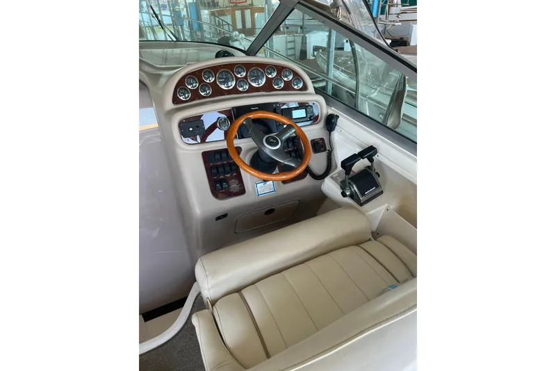Slide: The Image of 1999 Sea Ray 290 Sundancer helm with gauges, steering wheel, and controls. - 12
