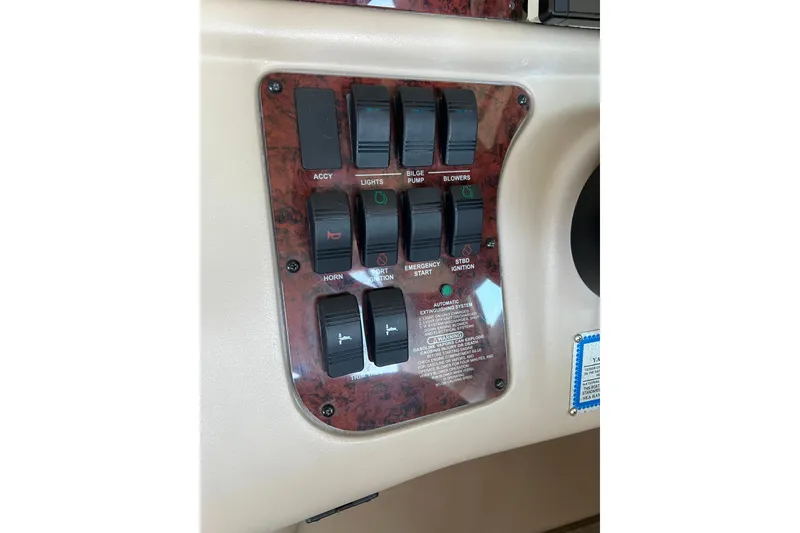 Slide: The Image of Control panel of a 1999 Sea Ray 290 Sundancer boat with various switches. - 15