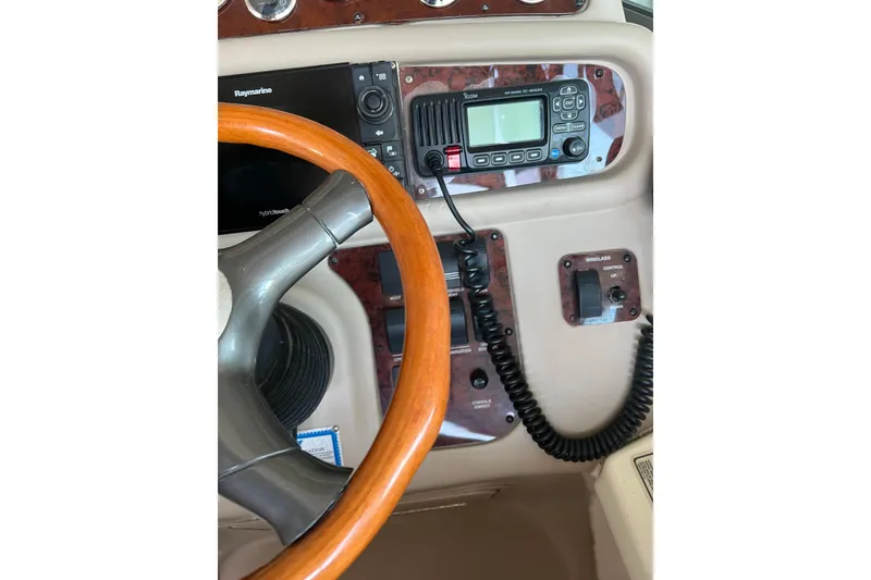 Slide: The Image of 1999 Sea Ray 290 Sundancer helm with steering wheel and navigation controls. - 16
