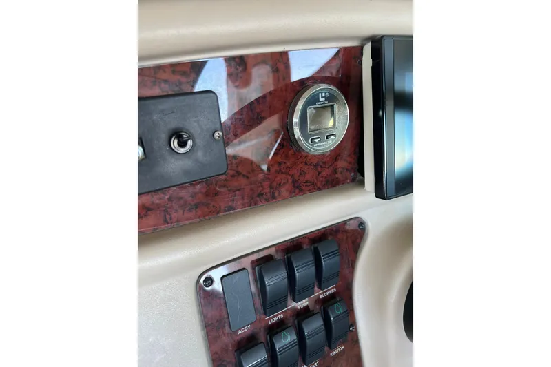 Slide: The Image of 1999 Sea Ray 290 Sundancer dashboard with depth gauge and control switches. - 18