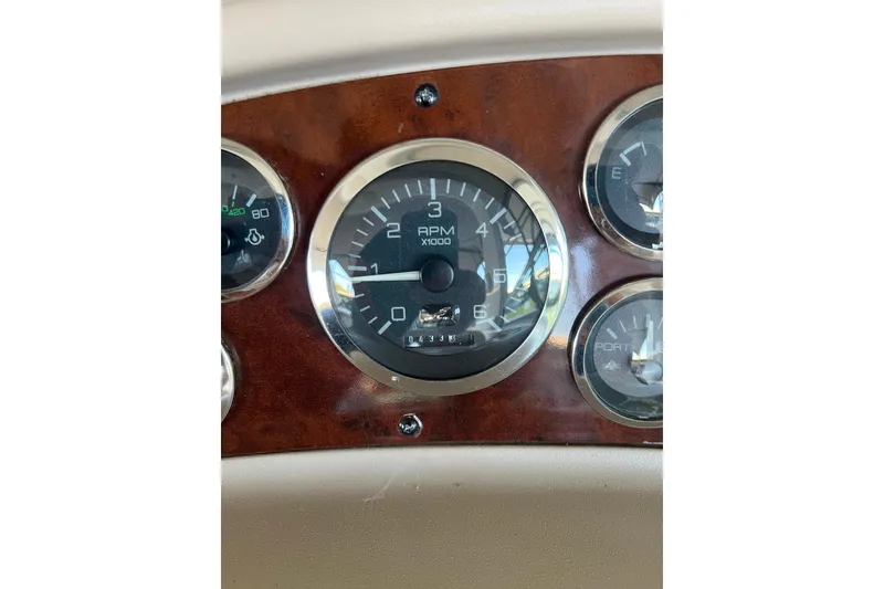 Slide: The Image of 1999 Sea Ray 290 Sundancer dashboard with RPM gauge and wood paneling. - 19