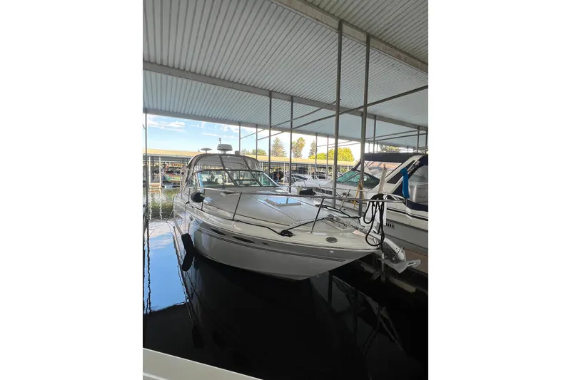 Slide: The Image of 1999 Sea Ray 290 Sundancer docked in a covered marina. - 2