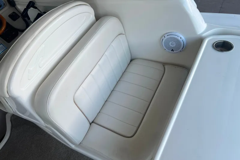 Slide: The Image of White leather seating on 1999 Sea Ray 290 Sundancer boat, featuring speaker and cup holder. - 22