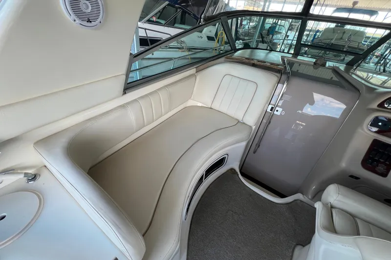 Slide: The Image of 1999 Sea Ray 290 Sundancer interior with beige seating and helm area. - 23