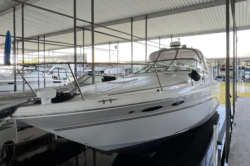 Slide: The Image of 1999 Sea Ray 290 Sundancer docked in a covered marina, showcasing sleek design. - 3