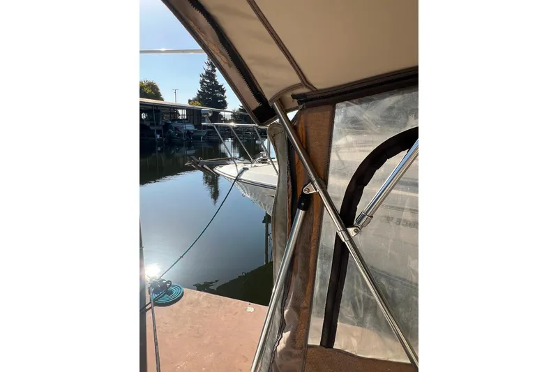 Slide: The Image of 1999 Sea Ray 290 Sundancer docked, viewed from under a boat canopy. - 9