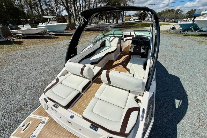 Slide: The Image of 2016 Regal 2300 Bowrider boat with spacious seating and sleek design, parked outdoors. - 11