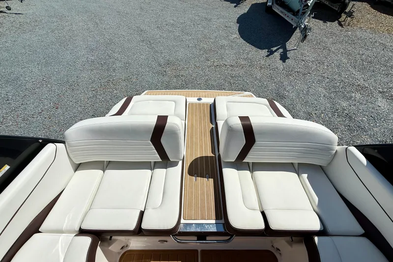 Slide: The Image of 2016 Regal 2300 Bowrider boat interior with white and brown seating, wooden deck. - 13
