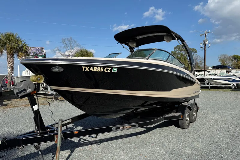 Slide: The Image of 2016 Regal 2300 Bowrider boat on trailer, parked outdoors under blue sky. - 8