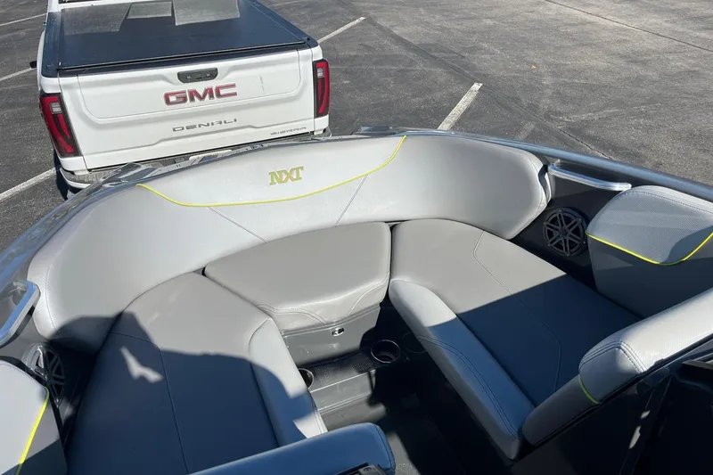 Slide: The Image of 2017 MasterCraft NXT22 boat interior with gray seating, parked near a GMC Denali truck. - 13