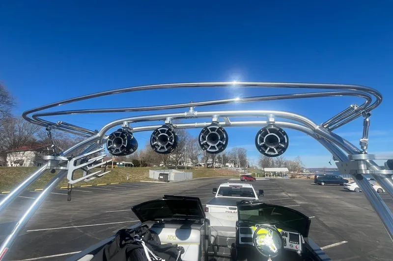 Slide: The Image of 2017 MasterCraft NXT22 boat with wakeboard tower and speakers, parked under clear blue sky. - 15