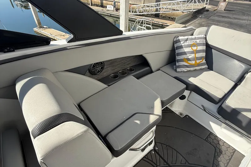 Slide: The Image of 2021 Scarab 255 ID boat interior with cushioned seating and nautical-themed pillow. - 10