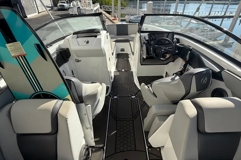 Slide: The Image of 2021 Scarab 255 ID boat interior with seating, steering wheel, and surfboard. - 14