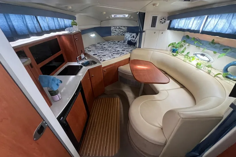 Slide: The Image of Interior of 2007 Bayliner 305 boat with cozy seating, kitchenette, and bed. - 12