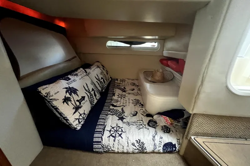 Slide: The Image of Cozy cabin interior of 2007 Bayliner 305 with nautical-themed bedding and soft lighting. - 15