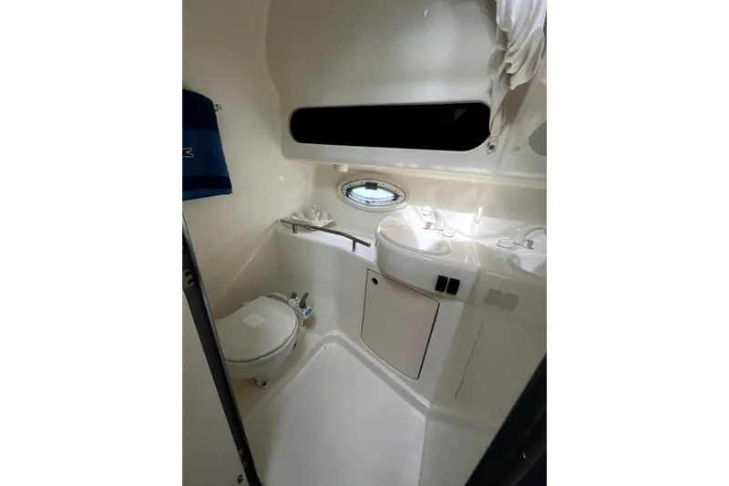 Slide: The Image of 2007 Bayliner 305 boat bathroom with toilet, sink, and porthole window. - 17
