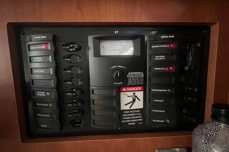 Slide: The Image of Electrical panel of a 2007 Bayliner 305 boat with various switches and warning labels. - 18