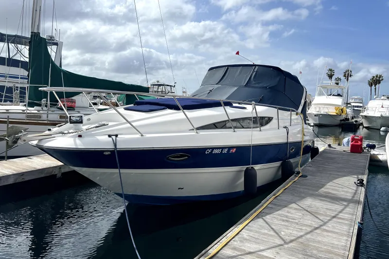 Slide: The Image of 2007 Bayliner 305 boat docked at marina under cloudy sky. - 2